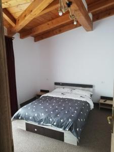 a bed in a room with a wooden ceiling at Pensiune Stirbu in Borsa