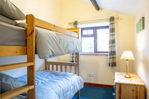 a bedroom with two bunk beds and a window at Hele Bay Cottage in Ilfracombe