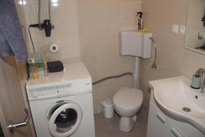 a small bathroom with a washing machine and a sink at Apartman ANA Livno - biker friendly in Livno +7 photos