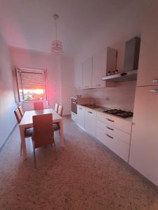 a kitchen with a table and a table and chairs at maison jolie - Agropoli da vivere- in Agropoli