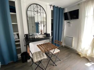 a dining room with a table and chairs and a mirror at Les Rives du Cher - Chambres d'hôtes in Montrichard