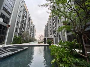a swimming pool in the middle of some buildings at Politan Breeze, Chaophraya River view in Ban Sai Ma