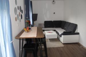 a small living room with a table and a couch at Apartman ANA Livno - biker friendly in Livno