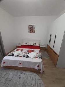 Schlafzimmer mit einem Bett mit einer roten und weißen Decke in der Unterkunft Apartament Ultra Central Marly Gura Humorului in Gura Humorului