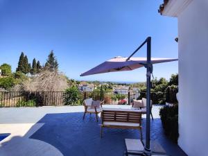un patio con mesa y sombrilla en Duende Marbella, en Marbella