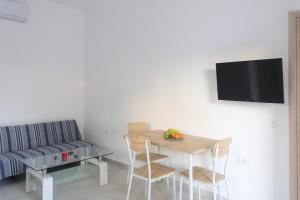 a living room with a table and a couch at Palm Studios in Perissa