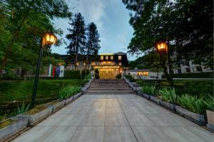 a large house with two lights on the front of it at Park Hotel Kaylaka in Pleven