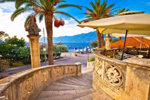a stone bridge with palm trees and a beach at La Casetta di Gloria in Lumbarda