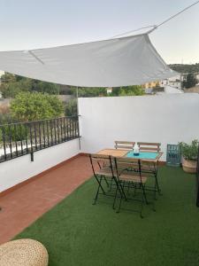 un patio con una mesa y sillas bajo un dosel blanco en Vivienda rural “Los Nacimientos”, en Alhama de Granada