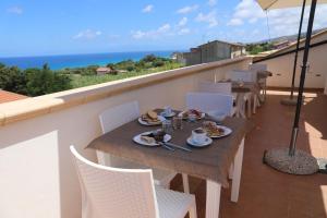a table with plates of food on a balcony at Blue Marine - Free Parking in Tropea