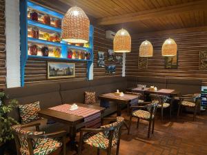 a restaurant with wooden tables and chairs and lights at Кайзервальд Карпати in Karpaty