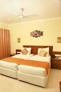 a hotel room with two beds in a bedroom at KTDC Grand Chaithram in Trivandrum