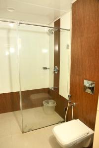 a bathroom with a toilet and a glass shower at KTDC Grand Chaithram in Trivandrum