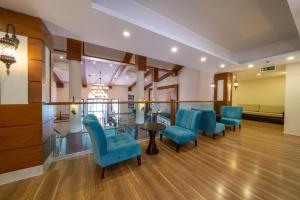 a waiting room with blue chairs and a table at Sundia By Liberty Oludeniz in Oludeniz