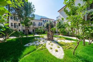 a garden with a tree in the middle of a building at Sundia By Liberty Oludeniz in Oludeniz