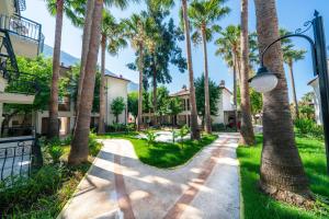 a walkway with palm trees and a street light at Sundia By Liberty Oludeniz in Oludeniz
