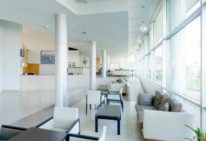a living room with white furniture and large windows at TRYP by Wyndham Porto Expo Hotel in Leça da Palmeira