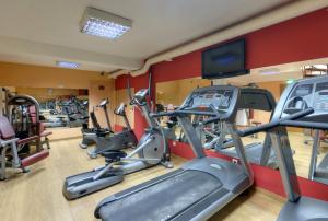 a gym with several tread machines and a flat screen tv at TRYP by Wyndham Porto Expo Hotel in Leça da Palmeira