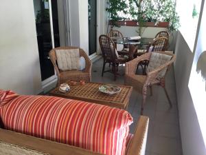 - une terrasse couverte avec un canapé, une table et des chaises dans l'établissement AGIA PARASKEVI appartement près du métro, à Athènes