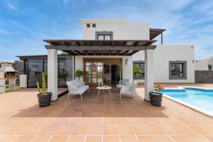 een villa met een zwembad en een patio bij Lanzarote Villa Zafiro Game Room 16 in Playa Blanca