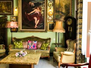 salon z kanapą i obrazami na ścianie w obiekcie Dwór Barocco w mieście Reszel