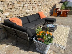 a couch and a table with flowers on a patio at Angliiska Vila in Arbanasi