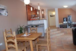 uma cozinha e sala de jantar com uma mesa de madeira e cadeiras em Moving Rooms em Wimpassing