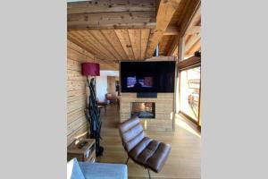 a living room with a chair and a fireplace at chalet Cocoa in Hauteluce