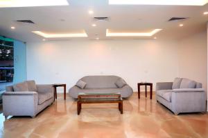 two chairs and a couch and a coffee table in a room at KTDC Grand Chaithram in Trivandrum