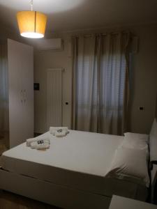 a bedroom with a large bed with two towels on it at Tindari guest house in Oliveri