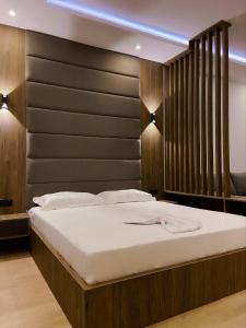 um quarto com uma cama grande e uma cabeceira em madeira em Donna em Ulcinj