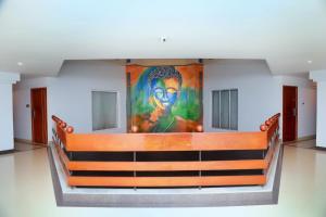 a painting on the wall of a room with a bench at KTDC Grand Chaithram in Trivandrum