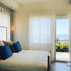 a bedroom with a bed and a large window at Villa Maria Luxury Suites in Sperlonga