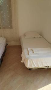 1 Schlafzimmer mit 2 Betten und Fliesenboden in der Unterkunft Mullaj Guest House in Vlorë