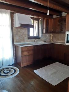 a kitchen with wooden cabinets and a sink and a window at ANASTASIA STONE HOUSE in Psakoudia