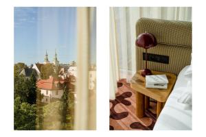 a room with a chair and a table with a window at PURO Kraków Stare Miasto in Krakow