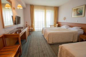 Een bed of bedden in een kamer bij Hotel Bellevue - Metropol Lake Resort
