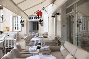 サン・マルタン・ド・レにあるホテル ド トワラスの白いテーブルと白いソファのあるレストラン