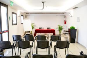 una habitación con sillas y una mesa con una mesa roja en Matrix Hotel & Residence, en Vigonza
