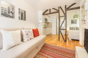 - un salon avec un canapé blanc et un tapis dans l'établissement Guest Inn Alfama, Premium Apartments, à Lisbonne