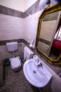 a bathroom with a sink and a toilet and a mirror at WELL COME - Palazzo Reale in Naples