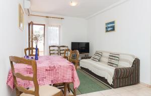 salon ze stołem i kanapą w obiekcie Apartmani Čižmešija w mieście Tkon