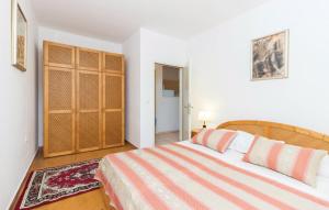 sypialnia z dużym łóżkiem i drewnianą szafką w obiekcie Apartmani Čižmešija w mieście Tkon