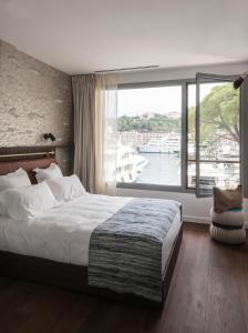 a bedroom with a large bed and a large window at Boutique Hotel Miramar in Monte Carlo