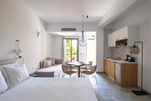 a bedroom with a bed and a kitchen with a table at Margo Beach Hotel in Gythio