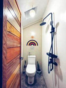 a bathroom with a toilet and a rainbow on the wall at Balay Hayahay Clohaki Hostel in General Luna