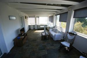 a living room with a white couch and a tv at Nona's House in Kalamaki