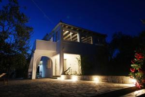 een groot wit huis met verlichting in de nacht bij Nona's House in Kalamaki