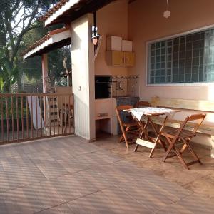 eine Küche mit einem Tisch und Stühlen auf einer Terrasse in der Unterkunft Recanto Flor de lis in Gonçalves