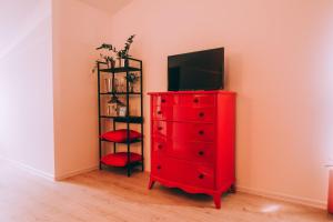 a red dresser with a television on top of it at X Rooms in Našice